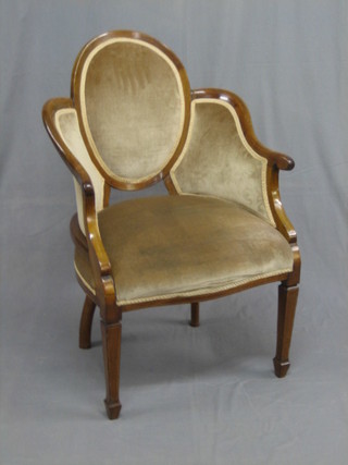 An  Edwardian  mahogany show frame  armchair  upholstered  in brown  material,  raised  on square  tapering  supports  ending  in spade feet