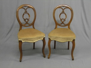 A  set  of 4 Victorian mahogany balloon back dining  chairs  with pierced  splat  backs,  the seats of  serpentine  outline,  raised  on  cabriole supports