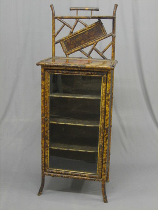 A  1920's  bamboo  cabinet with raised back,  the  interior  fitted shelves enclosed by a glazed panelled door 22"