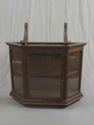 A  Victorian oak hanging cabinet of lozenge form enclosed  by  a panelled door 38"