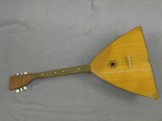 A  6 stringed musical instrument with triangular shaped  wooden body 27" overall