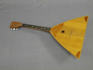 A  3 stringed wooden musical instrument with triangular  shaped body 27" overall