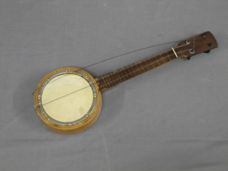 A 4 stringed banjo with 6" drum with 8 brass screws