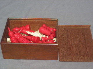 A  32  piece red and white carved ivory chess set contained  in  a wooden box
