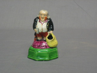 A 19th Century Staffordshire figure of a standing gentleman with bag, raised on an octagonal base 4"