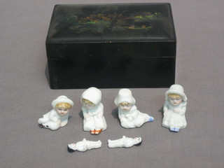 A   rectangular  lacquered  box  containing  4   Kate   Greenaway miniature  biscuit  porcelain dolls and 2 Oriental  porcelain  dolls