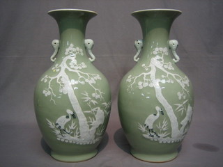 A  pair of Oriental Celadon ground twin handled vases  decorated storks by trees 16" (1 cracked and 1 with bung for lamp)