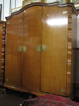 A 1930's Queen Anne style walnut triple wardrobe with moulded cornice, raised on cabriole ball and claw supports 67"
