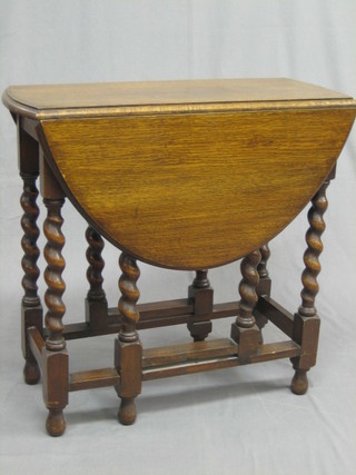 A  1920's honey oak drop flap gateleg tea table, raised  on  spiral turned supports 28"
