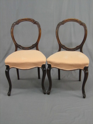 A set of 6 Victorian rosewood hoop back dining chairs, the  seats of   serpentine   outline,   raised  on   French   cabriole   supports