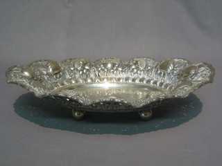An embossed oval Eastern white metal dish raised on 3 bun  feet, base marked 800 22 ozs