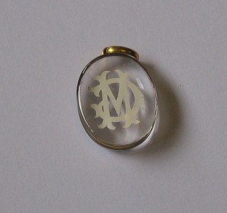 A   Victorian   oval  cut  crystal   pendant,   monogrammed   MC contained in a gilt mount