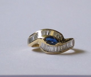 A  modern  18ct  gold  dress  ring  set  a  sapphire  supported  by baguette cut diamonds