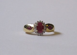 A  lady's  gold  dress ring set an oval ruby to  the  centre  and  2 rubies   to  the  shoulders,  surrounded  by  numerous   diamonds