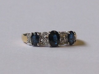 A  lady's  9ct gold dress ring set 3 oval  sapphires  supported  by diamonds