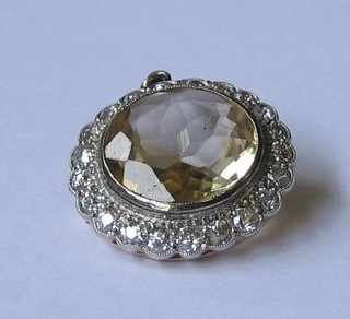 A  lady's  handsome yellow stone pendant/brooch  surrounded  by numerous   diamonds   and  surmounted  by  a   single   diamond