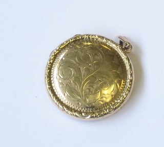 A circular engraved 9ct gold locket