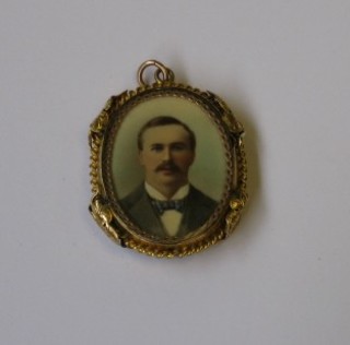 A  gilt  metal  double  sided locket,  1  side  containing  an  early coloured photograph of a gentleman and family