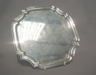 A  square silver plated salver with bracket border, raised  on  bun feet 10"
