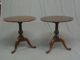 A  pair of circular Georgian style mahogany  snap  top  telephone tables, raised on pillar and tripod supports 25"