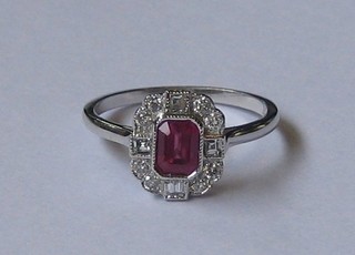 A  lady's  18ct  white gold dress ring set a  rectangular  cut  ruby supported by 4 baguette cut diamonds and surrounded by 10 other diamonds