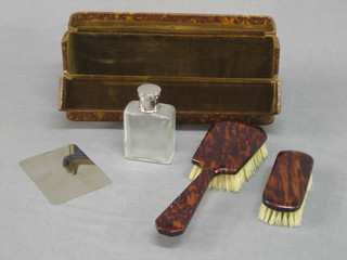 A  1920's simulated tortoiseshell hairbrush with matching clothes brush,  cologne  bottle and steel mirror contained in  a  travelling  case