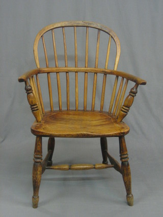 An  18th/19th Century elm comb back Windsor chair with  solid elm  seat,  raised  on  turned supports  with  H  framed  stretcher