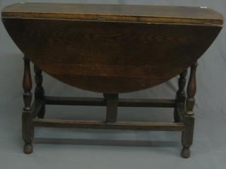 A  19th/20th  Century  oak  oval gateleg  dining  table  raised  on turned and block supports 42"