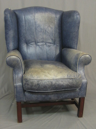 A  Georgian  style  winged armchair upholstered  in  blue  leather