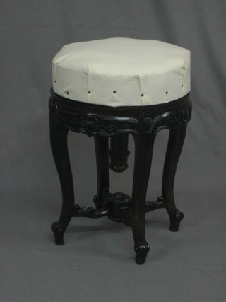 A  Victorian  carved mahogany revolving adjustable  piano  stool, raised on cabriole supports