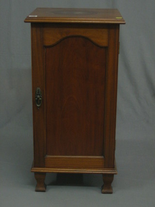 An   Edwardian  walnut  pedestal  pot  cupboard  enclosed  by   a panelled door, raised on square shaped supports 16"
