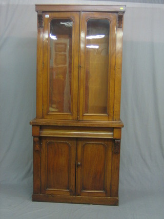 A  Victorian  mahogany  bookcase on  cabinet  the  upper  section with   moulded   cornice  the  interior  fitted   adjustable   shelves enclosed  by  arch shaped panelled doors, the base fitted  1  long drawer  above a double cupboard, raised on a platform  base  35"