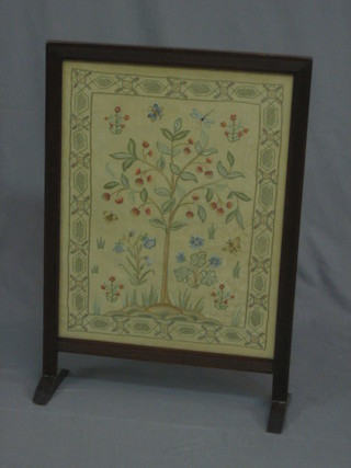 A tapestry fire screen contained in a mahogany frame
