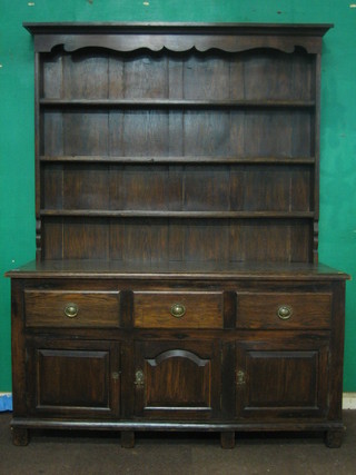 A  Victorian  oak dresser with moulded cornice, the  raised  back fitted 3 shelves, the base fitted 3 drawers above triple  cupboards,  on square supports 60"