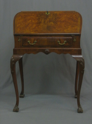 A  Queen  Anne  style  walnut bonheur  du  jour  with  fall  front revealing a well fitted interior, the base fitted a drawer, raised on cabriole supports 27"