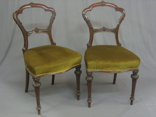 A pair of Victorian mahogany balloon back bedroom chairs  with carved mid rails and upholstered seats, raised on turned  supports