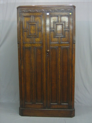 A  1930's  oak hall wardrobe enclosed by  arcaded  and  panelled doors 38"