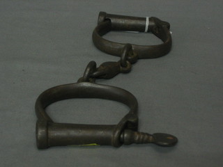 A  pair  of 19th/20th Century steel handcuffs complete  with  key marked Hiatt