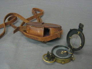 A  WWI military issue prasmatic compass contained in  a  leather carrying case