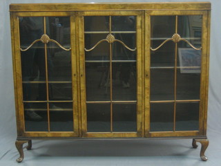 An Art Deco walnut display cabinet, the interior fitted  adjustable shelves  enclosed  by  astragal  glazed  panelled  door,  raised  on  cabriole supports 53"