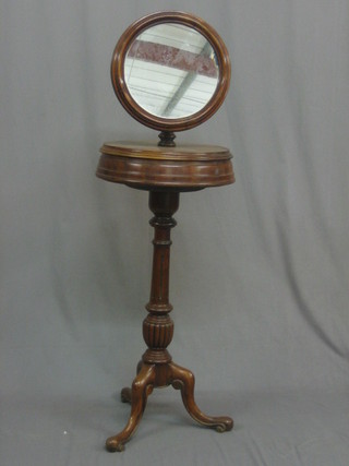 A  Victorian mahogany shaving stand with circular plate  mirror, the base fitted a twin compartment, raised on a fluted column and tripod supports 