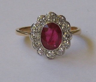 A lady's 18ct gold dress ring set an oval cut ruby surrounded by 12 diamonds (approx 0.60/1/15ct)