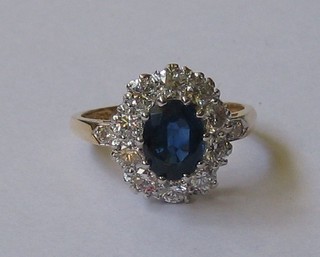 An 18ct yellow gold dress ring set a large sapphire surrounded by 11 diamonds and 2 to the shoulders (approx 1/1.50ct)