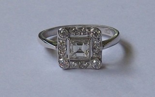 An 18ct white gold dress ring set a square cut diamond supported by 14 small diamonds (approx 0.85ct)