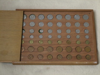 A collection of coins contained in a wooden tray