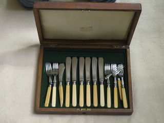 A collection of various silver plated fish knives and forks in an oak canteen box