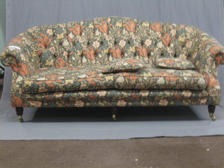 A Victorian style mahogany framed 2 seat settee upholstered in floral material