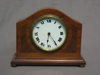 A French 8 day bedroom timepiece with enamelled dial and Roman numerals contained in an inlaid mahogany arch shaped case