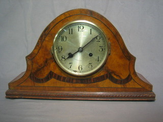 A 1930's striking mantel clock with silvered dial contained in a walnut arch shaped case