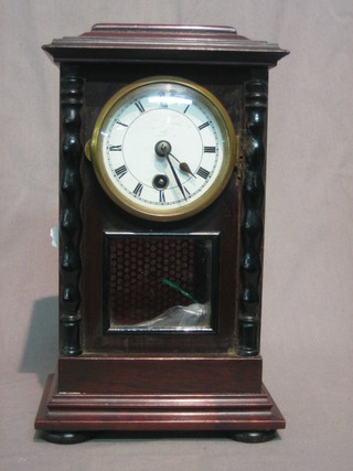 An 8 day mantel clock with 2" paper dial with Roman numerals contained in a mahogany case